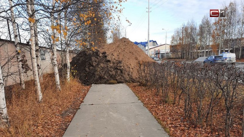 В Сургуте огромная куча земли преградила путь пешеходам на одном из тротуаров