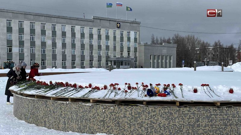К стихийному мемориалу в Сургуте жители несут цветы